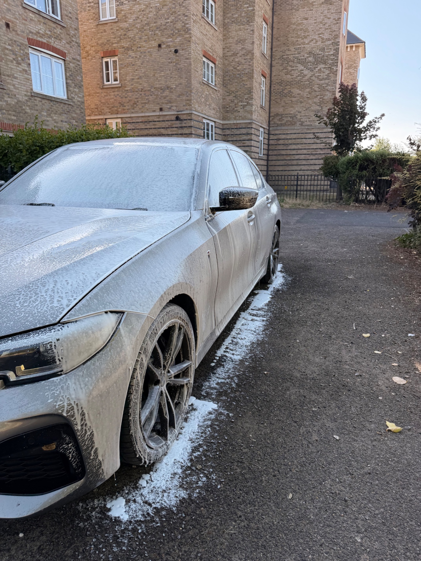 Silver BMW covered in snow foam during a premium exterior detail by AM Prestige